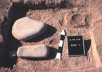 Two metates found lying face down on the floor of Room 11, a pithouse. In the upper right is a small cache of potters clay that was placed in a shallow basin.