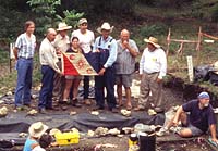 Volunteers from the 2001 Texas Archeological Society Field School proudly show off an Expedition Flag from the Explorers Club of New York. This well-traveled flag has been to the South Pole and many other places in the world.