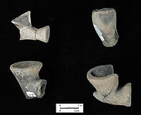 Tobacco pipe bowls; upper left specimen is carved stone and the others are ceramic. Photo by Milton Bell.