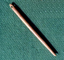 photo of eyed needle made of polished bone