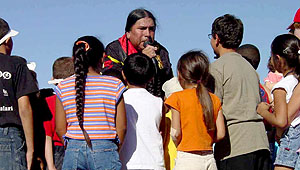photo of a Kiowa leader talking to children about Native American heritage at Hueco Tanks