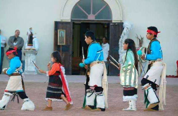 photograph of five youth in dance outfits in front of a church