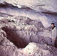 Archeologist Mark Parsons stands in one of the many looter holes that left the interior of Fate Bell Shelter looking like a WW I trench warfare scene.