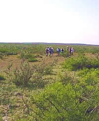 An archeological survey team gathers on this upland area. Standing in the middle of one of the flat upland areas between the canyons, it looks as though vast unbroken plains stretch in every direction. Yet less than a hundred yards away is a deep canyon. Photo by Steve Black.