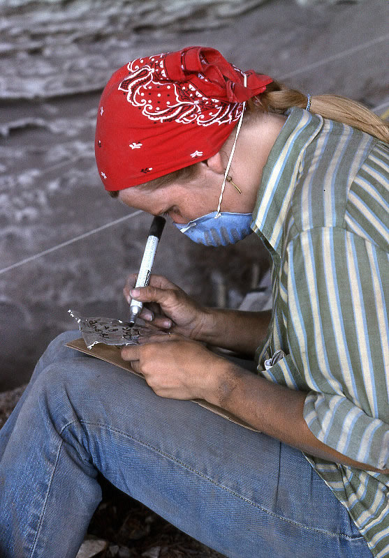 photo of seated woman in field clothes with felt pen in hand