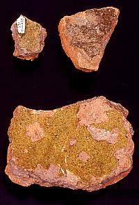 Sherds of Spanish olive jar and green-glazed wares. These broken pieces of pottery represent types that are diagnostic of the Spanish colonial era in Texas. One of the large green-colored sherds is the one that Kay Hindes found the day the site was discovered in 1993. 