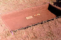 In this shallow archeological unit, excavated out in the alfalfa field, a layer of lighter soil at the top indicates the plow zone. This is the layer of soil turned over each time the field is plowed or disked. Much of the original deposit containing remains of the mission had been disturbed by farming activities over the past century. Hall estimates that, with another 20 years of plowing, all original remnants of the mission, such as filled pits and post stains, would have been destroyed. 