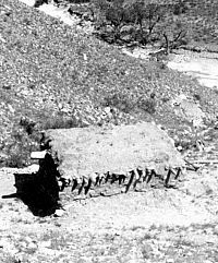 B&W photo of adobe room with flat, pueblo-like roof.