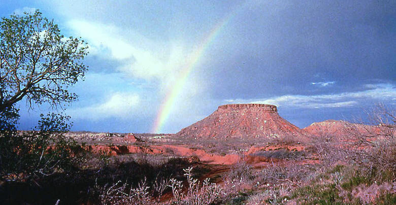 Photo of stone ruins on top of Landergin Mesa in Oldham County with rainbow in the background