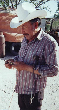 Photo of Juan Avila carving a curved wooden honda