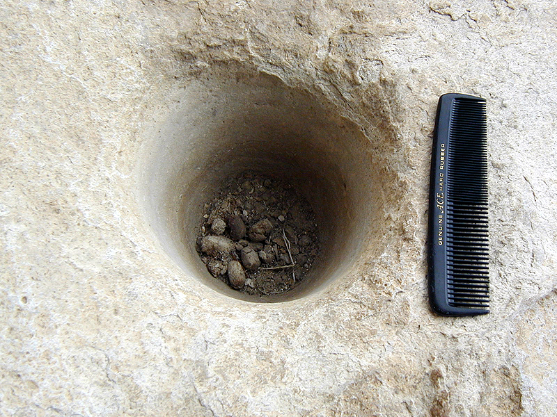 A wooden pestle may have been used to pound mesquite beans or similar resources into flour in this bedrock mortar hole at Eagle Cave.