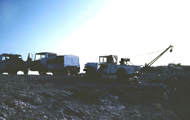 Winch and generator trucks parked at edge of cliff, 1983. Photograph by Solveig Turpin.