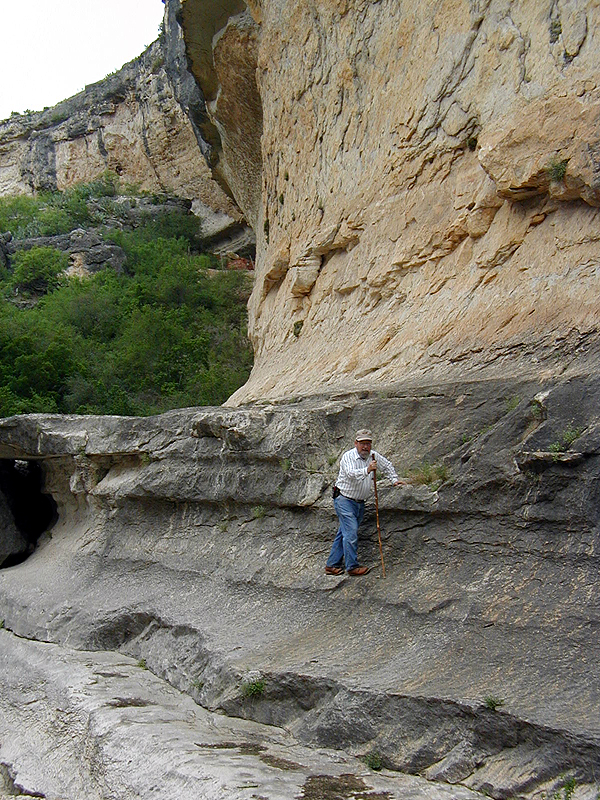 Elton Prewitt on the precarious "trail" used by 1963-64 excavation crew to approach Bonfire Shelter. The shelter is visible on the upper left.