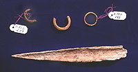 Bone awl and burned bone rings found in an irregular trash-filled pit between rooms 13 and 17.