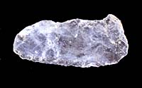 Clovis point fragment made out of clear quartz crystal, a material that does not occur locally. Several quartz crystal flakes found at the site hint that this unusual material was brought to the site in a raw or partially worked state.