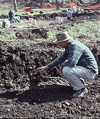 Mike Collins points out an artifact at the Gault site. The disturbed area is a trench where machines have been used to removed overburden—the site's massive archaic deposits were thoroughly churned up by artifact collectors over a 60-year period.