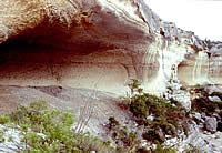 rockshelter and grey mounds of debris