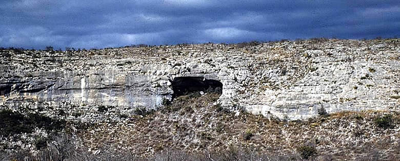 photograph of a long rockshelter entrance in a cliff face