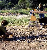 Photo of initial excavations underway on south side of highway. Here the top of a "sheet" midden, or thin burned rock accumulation, is being exposed. Leon Creek is in the background.