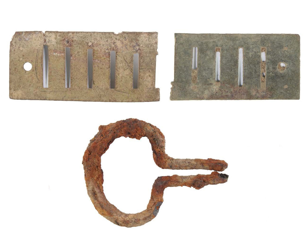 Photograph of metal musical instrument parts on a white background with a scale bar.