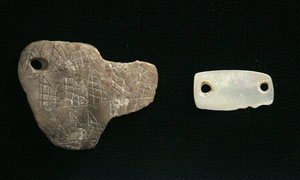 photo of incised pendant and shell pendant recovered from Squawteat Peak