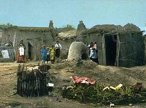 photo of mud-plastered jacal structures and outdoor ovens